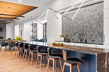 a large kitchen with a long counter and chairs in front of it